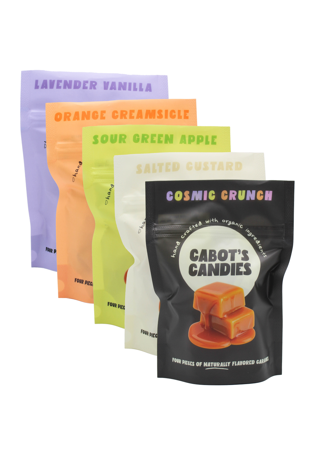 Five stand-up candy pouches fanned out on a white background, each in a different flavor color: lavender vanilla, orange creamsicle, sour green apple, salted custard, and cosmic crunch. The front pouch is black with a caramel candy photo and the brand name Cabot's Candies.